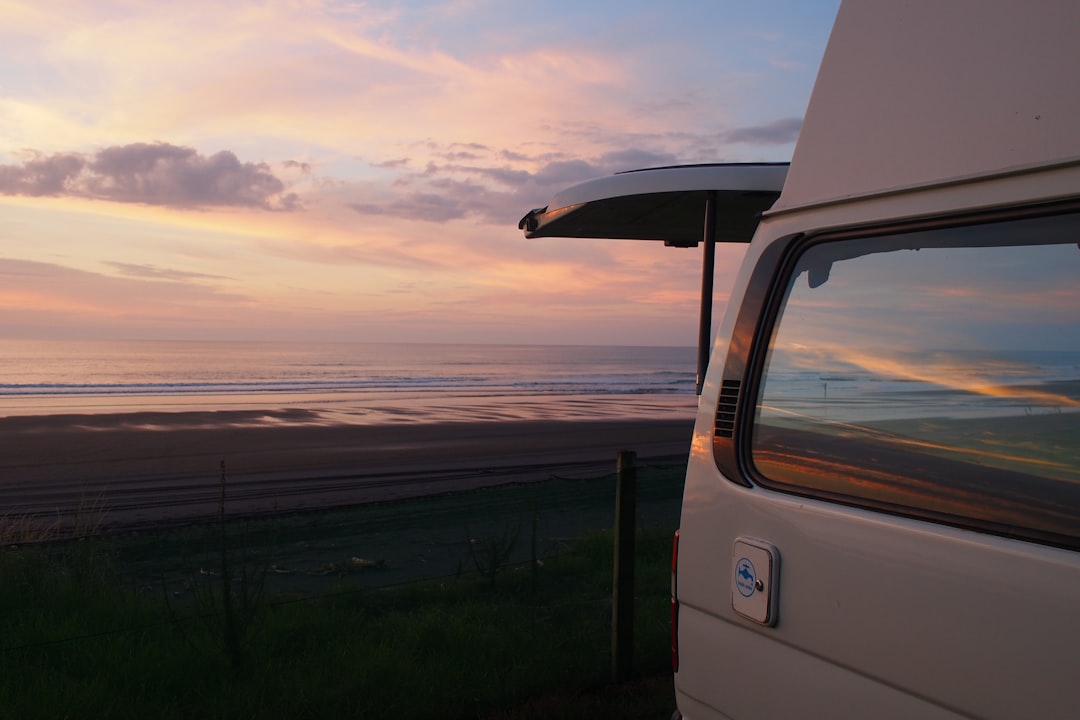 Camper vicino al mare Camper parcheggiato vicino al mare al tramonto — foto di Alice Hartrick su Unsplash